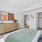 Large well lit bedroom with plush carpets and large windows 