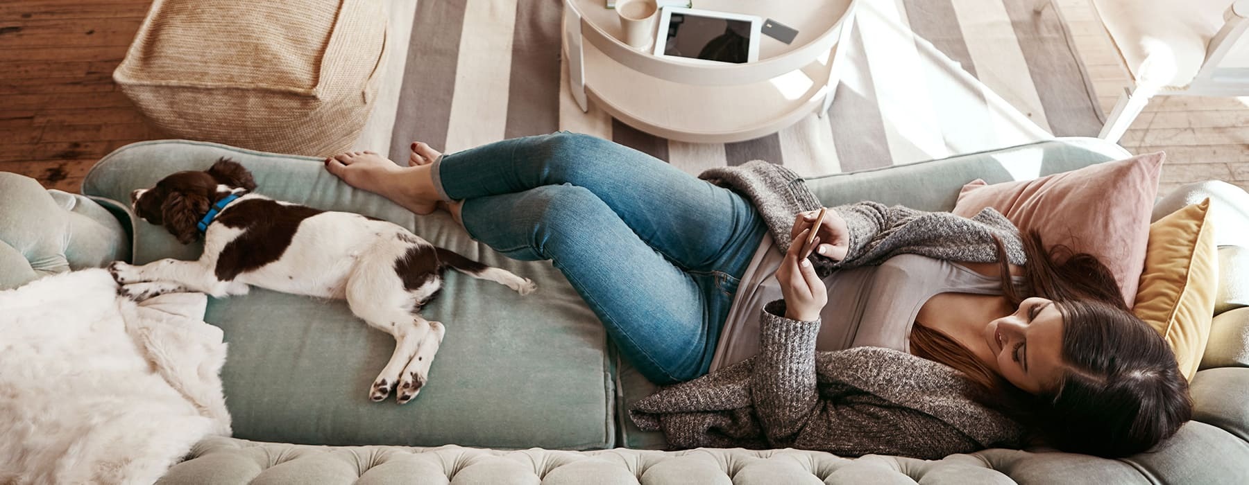 lifestyle image of a woman laying beside a pet in a living room